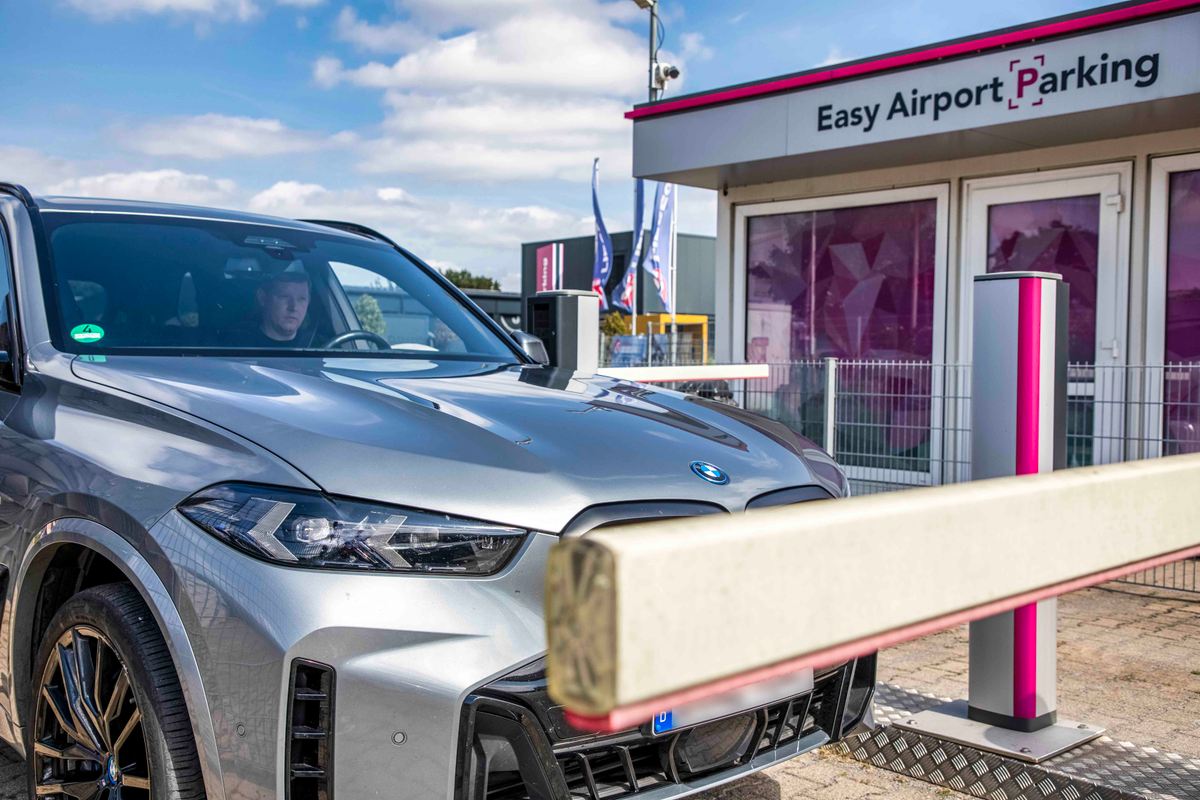 SUV voor de toegangsslagboom van de Easy Airport Parking-parkeerplaats bij de luchthaven van Dortmund (DTM)