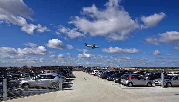 Airplane flying over the outdoor deck of the parking garage of Easy Airport Parking at Hamburg Airport (HAM)