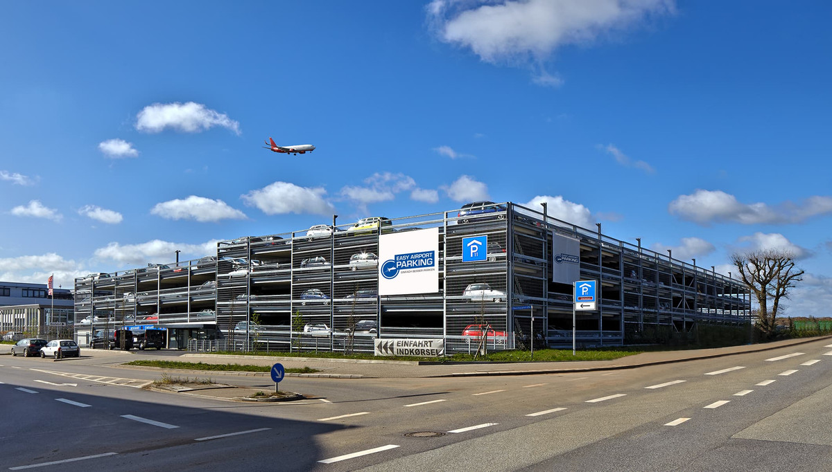 Street view of the multi-storey Easy Airport Parking garage with landing airplane at Hamburg Airport (HAM)