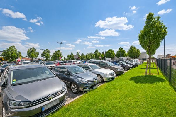Well-maintained green areas at the edge of the car-filled parking lot of Easy Airport Parking at Stuttgart Airport (STR)