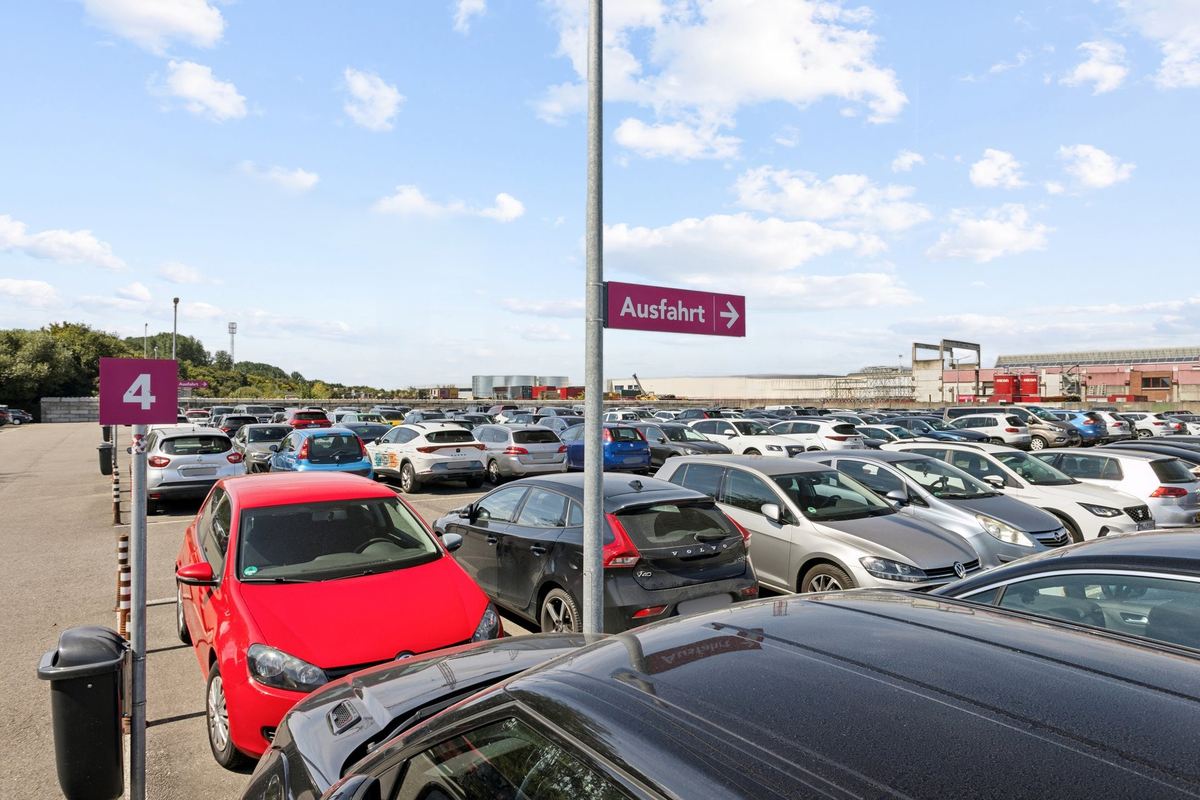 Parked cars and information signs at the Easy Airport Parking parking lot at Weeze Airport (NRN)